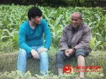 农民日报记者和邓再良坐在地头聊天。刘飞 摄 - News.Cntv.Cn